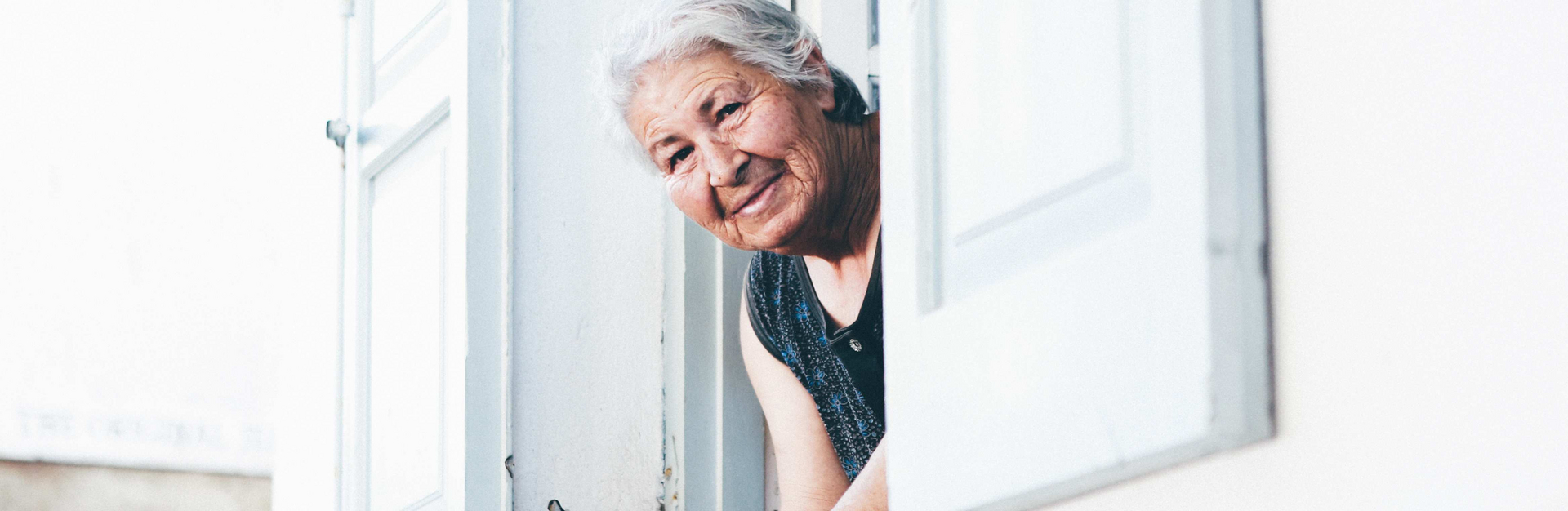 Frau mit Alzheimer schaut aus dem Fenster