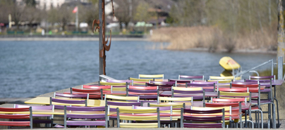 Farbige Stühle an einem See