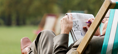 Ein ältere Mann löst ein Kreuzworträtsel