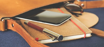 Notizbuch und Smartphone in einer Tasche