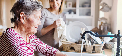 Une femme âgée et une jeune femme faisant la vaisselle