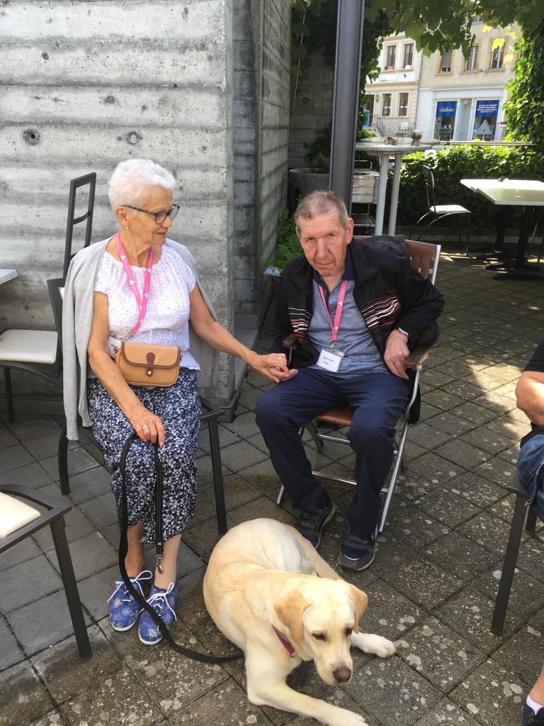 Zwei sitzende Senioren mit Hund